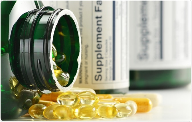 Composition with dietary supplement capsules and containers. Variety of drug pills - Image Credit: monticello / Shutterstock