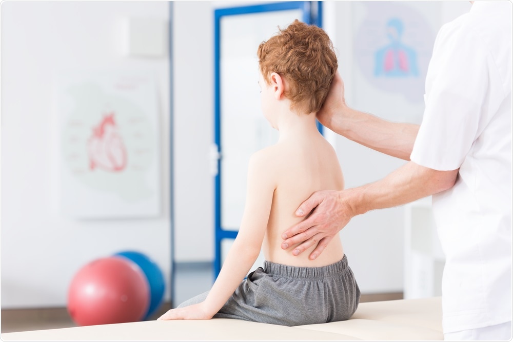 Picture of child with scoliosis being checked over by doctor - Photographee.eu