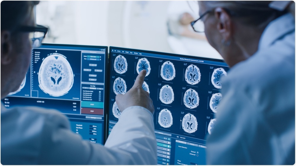 Doctors looking at MRI scan of patient with potential brain cancer.