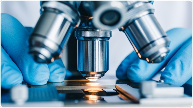 Scientist looking down microscope