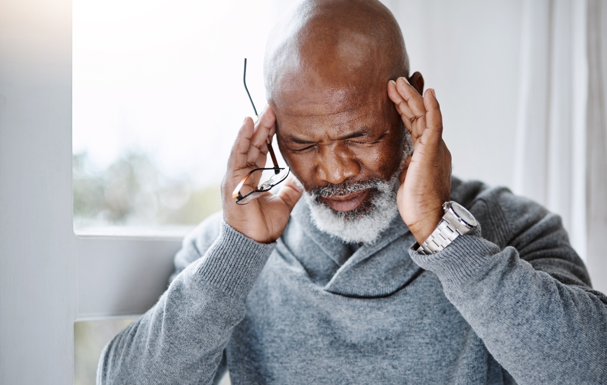 Headache, pain and senior man with migraine, mental health risk, retirement stress or mind problem at home.