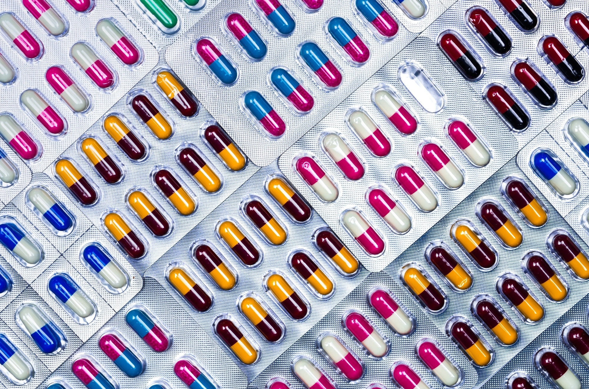 Full frame of colorful antimicrobial capsule pills. Quality control error in pharmaceutical manufacturing.