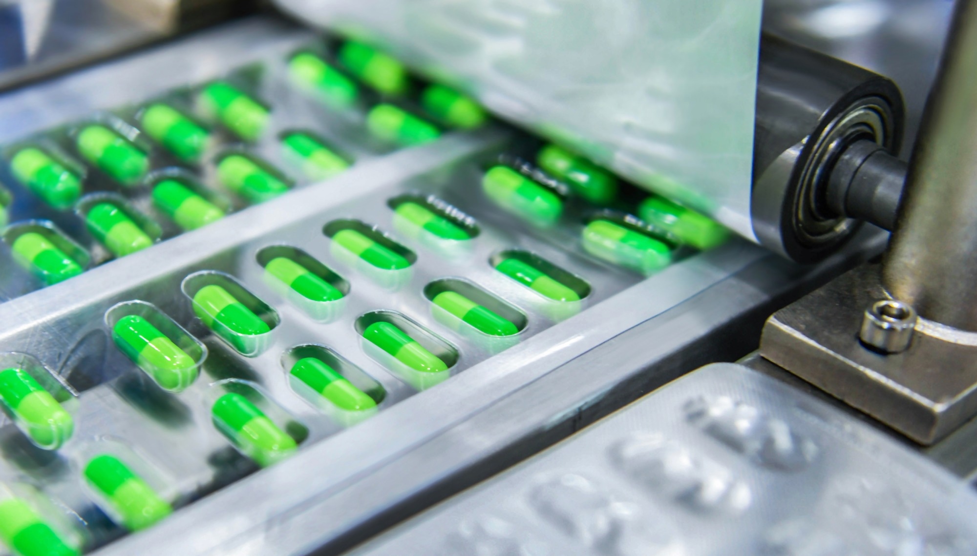 Green capsule medicine pill production line, Industrial pharmaceutical concept.