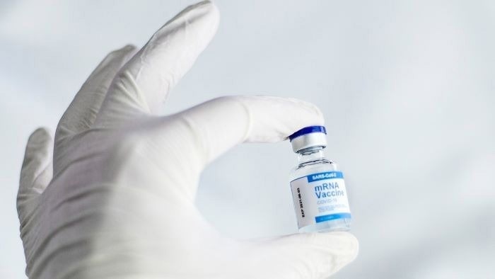 Gloved hand holding mRNA vaccine